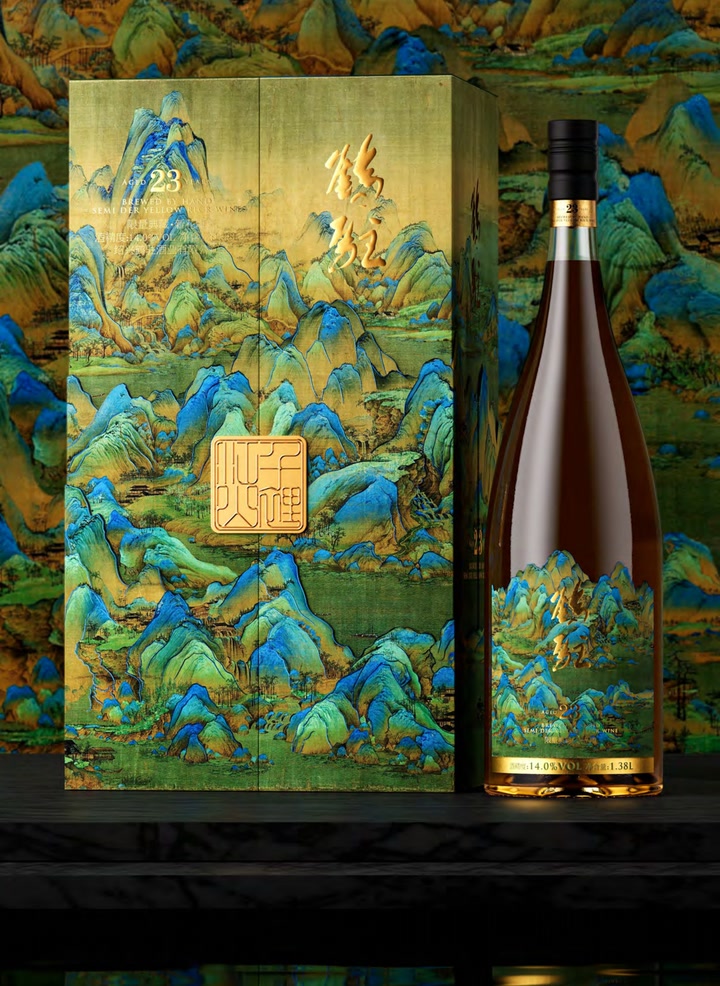 The closed landscape gift box with a gold seal on its face at the left, the bottle at the right, reflected in a black surface